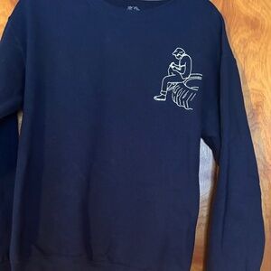 Blue Sweatshirt with Outsiders Broadway logo and opening line on back